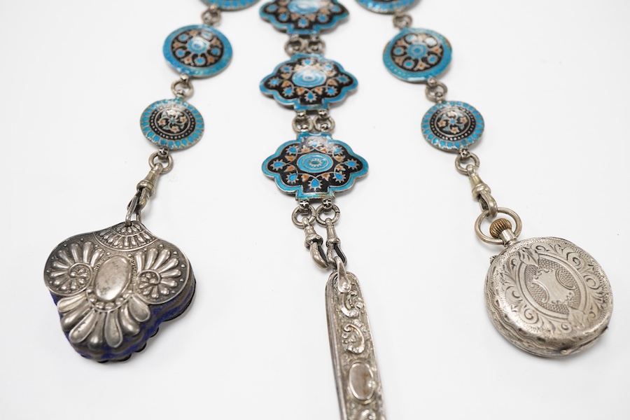 An enamel chatelaine, late 19th/early 20th century, composed of metal plaques applied with foliate patterns in blue, black and red enamel, indistinctly stamped maker's marks, suspending a silver pin cushion and a silver
